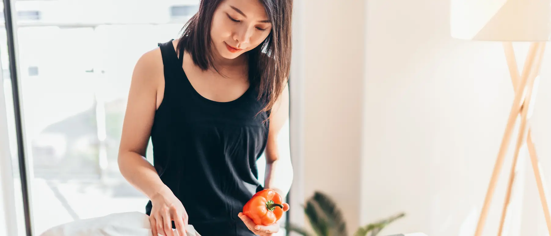 A woman unpacks her shopping from a canvas tote bag.