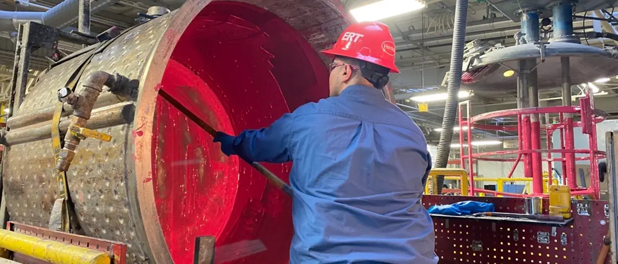 Man in hard hat cleaning machinery