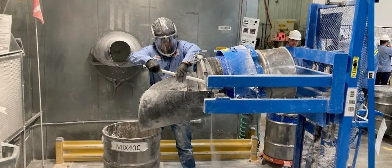 Employee operates machinery to weigh and sort materials