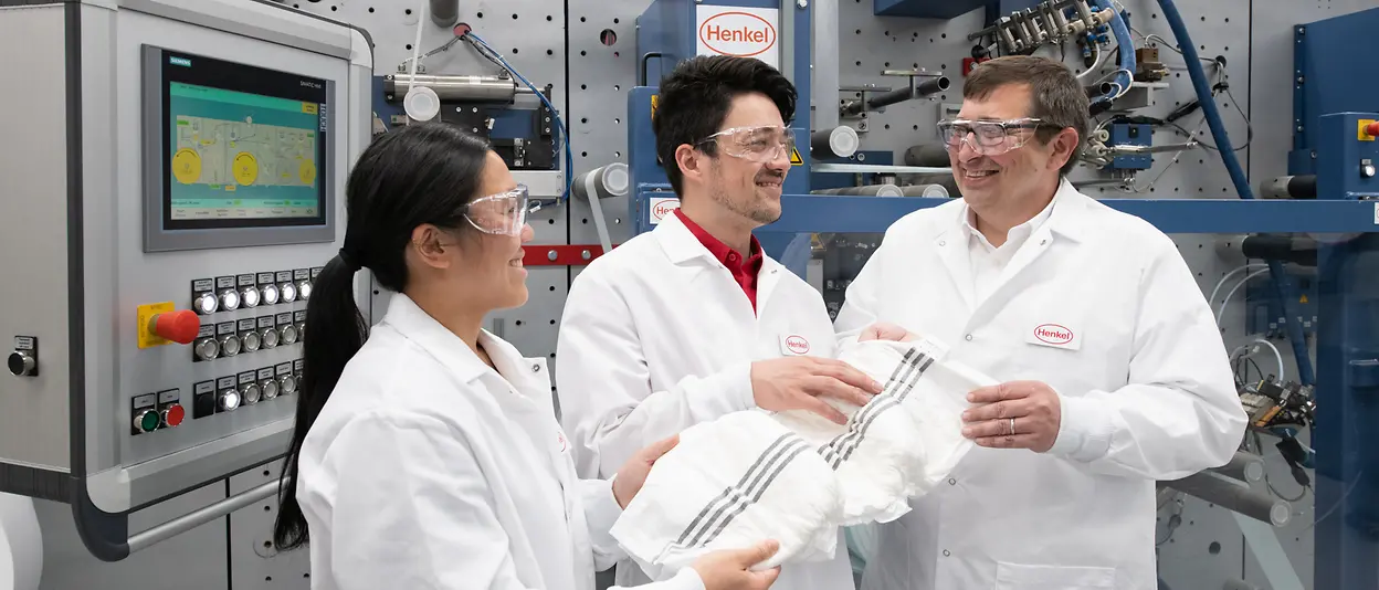 Three Henkel scientists standing in the Bridgewater Technology Center holding smart diaper solutions.