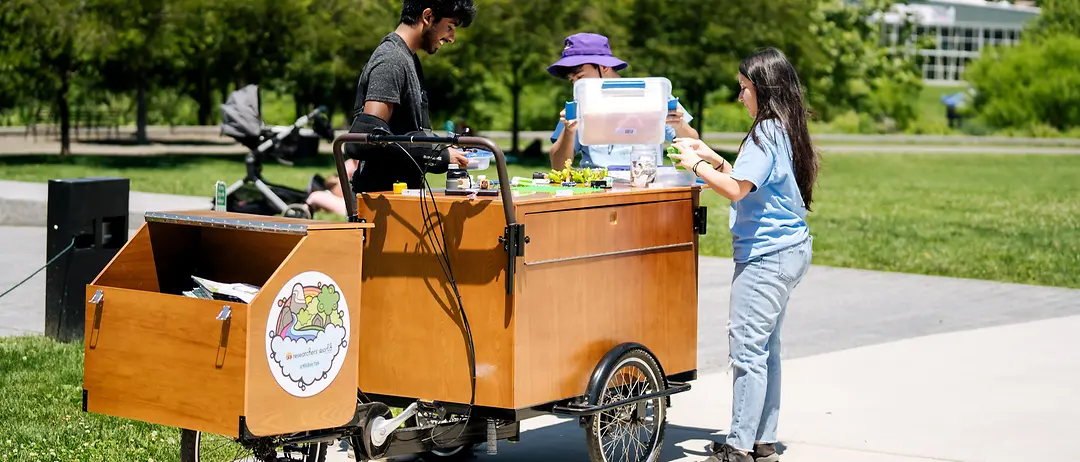 A mobile learning cart branded with Henkel’s Researchers’ World and a child exploring it.