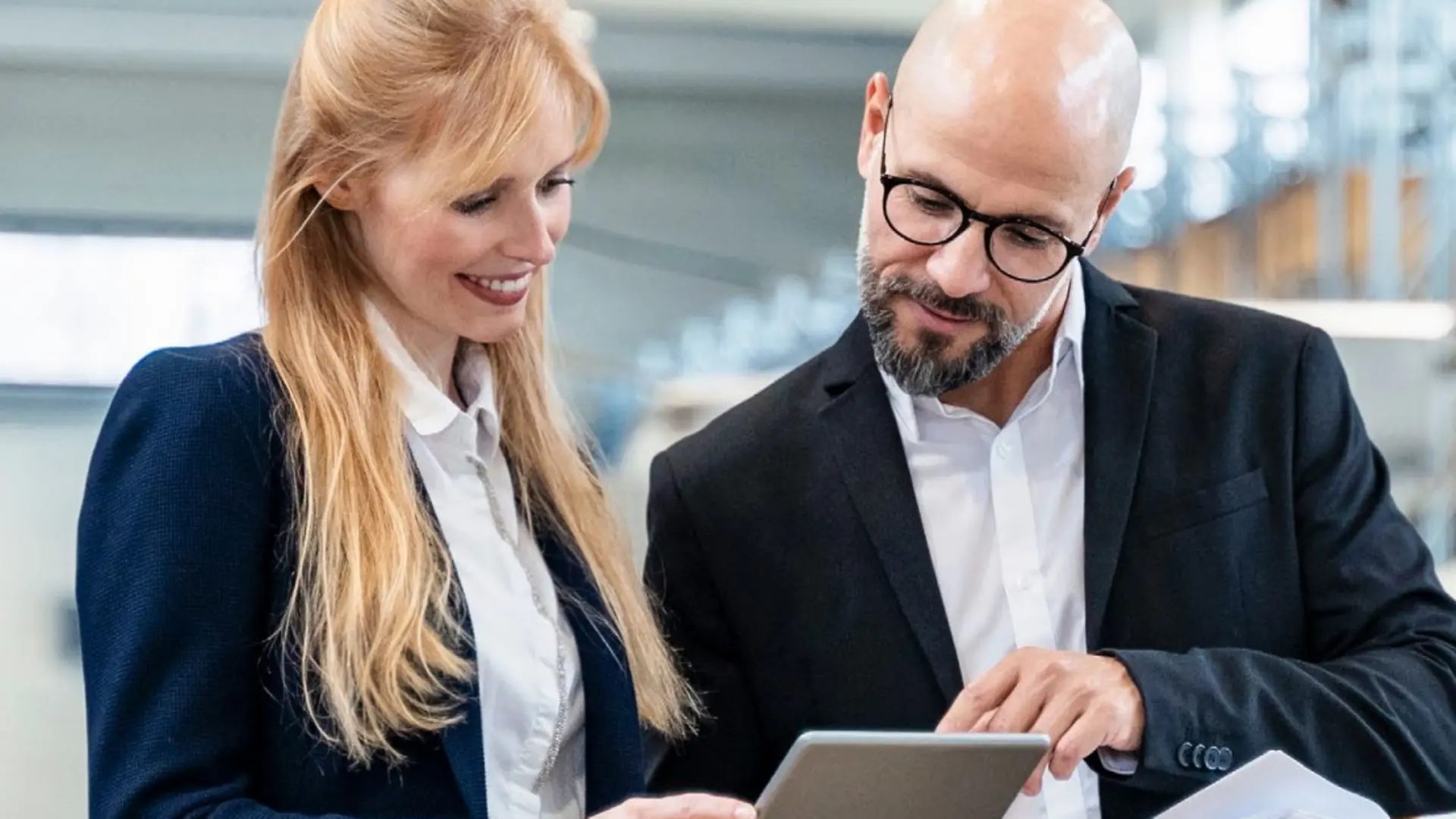 man and woman looking at a tablet