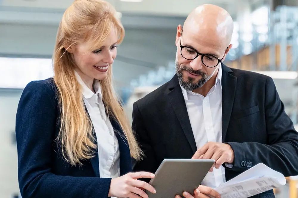 man and woman looking at a tablet