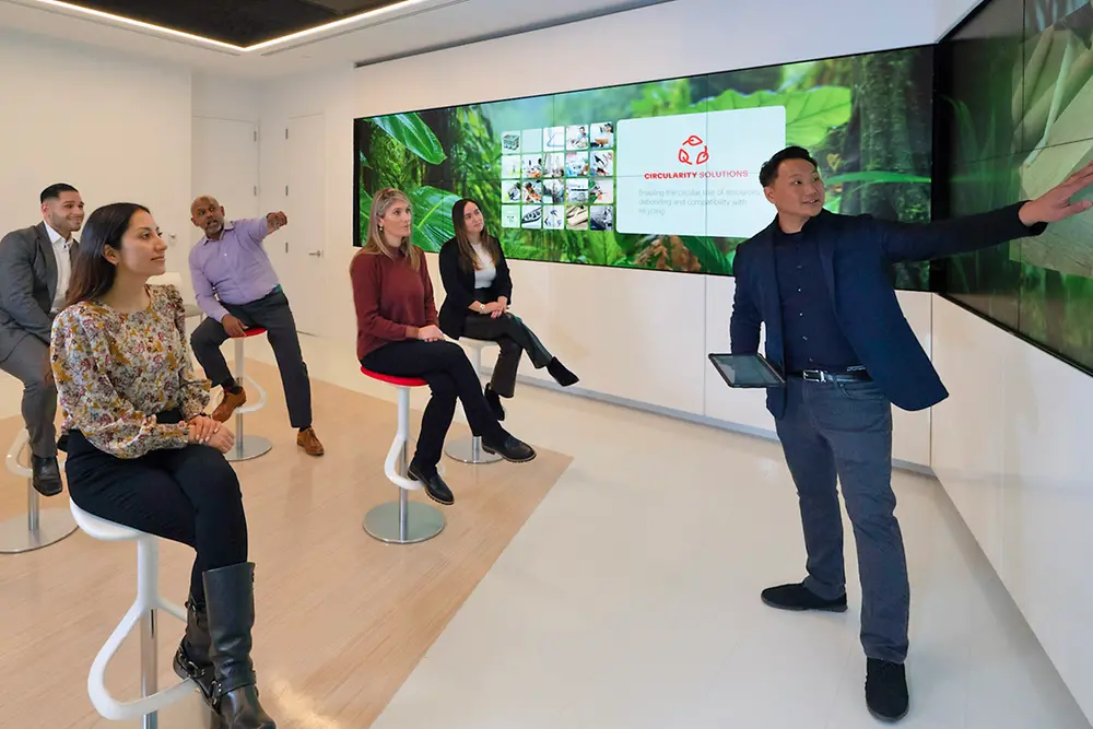 A customer experience tour guide shows a group of customers the Infinity Room at the Technology Center Bridgewater.