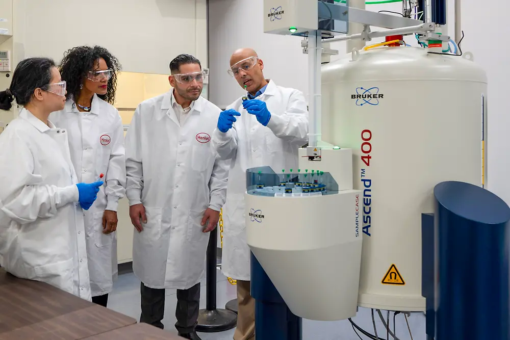 People in lab coats discuss a test in a laboratory at the Technology Center Bridgewater.