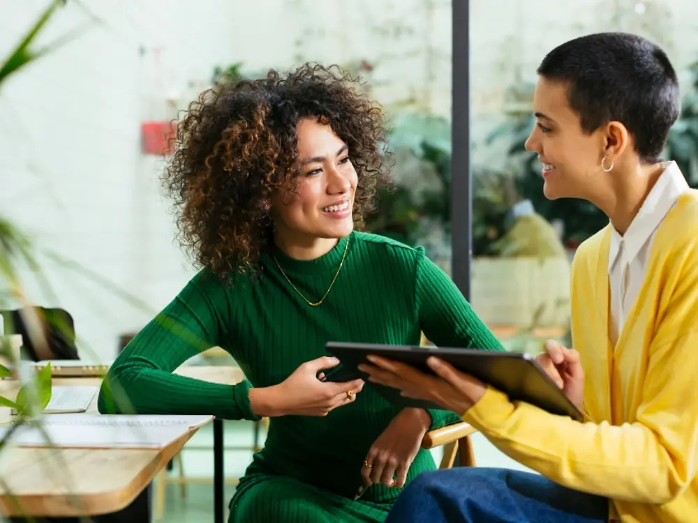 Women work colleagues talking to each other.